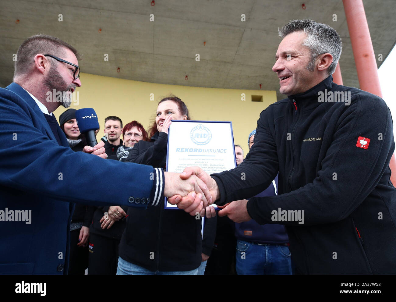 Ronneburg, Allemagne. 06 Oct, 2019. Rolf Allerdissen (l) à partir de 500 l'Institut für Deutschland félicite Bernd Lehmann, chef de l'association "Nous4Kids' sur le record du monde du 994 mètres, 5 de la pâtisserie "Kalter Hund'. Les enfants et les employés de l'association "Nous4Kids' produit le biscuit 'Kalter Hund' de chocolat et biscuits et voulait établir un nouveau record du monde avec une longueur totale de 1000 mètres. Les biscuits sont ensuite vendues au profit d'un projet d'aide. Credit : Bodo Schackow Zentralbild-/dpa/dpa/Alamy Live News Banque D'Images