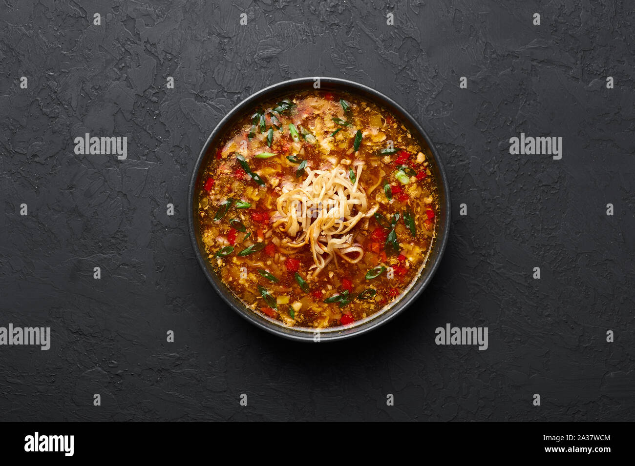 Veg Manchow soupe dans un bol noir dark slate à fond. Manchow soupe végétarienne est l'indo-chinoise plat avec les poivrons, le chou, carotte, nood Banque D'Images