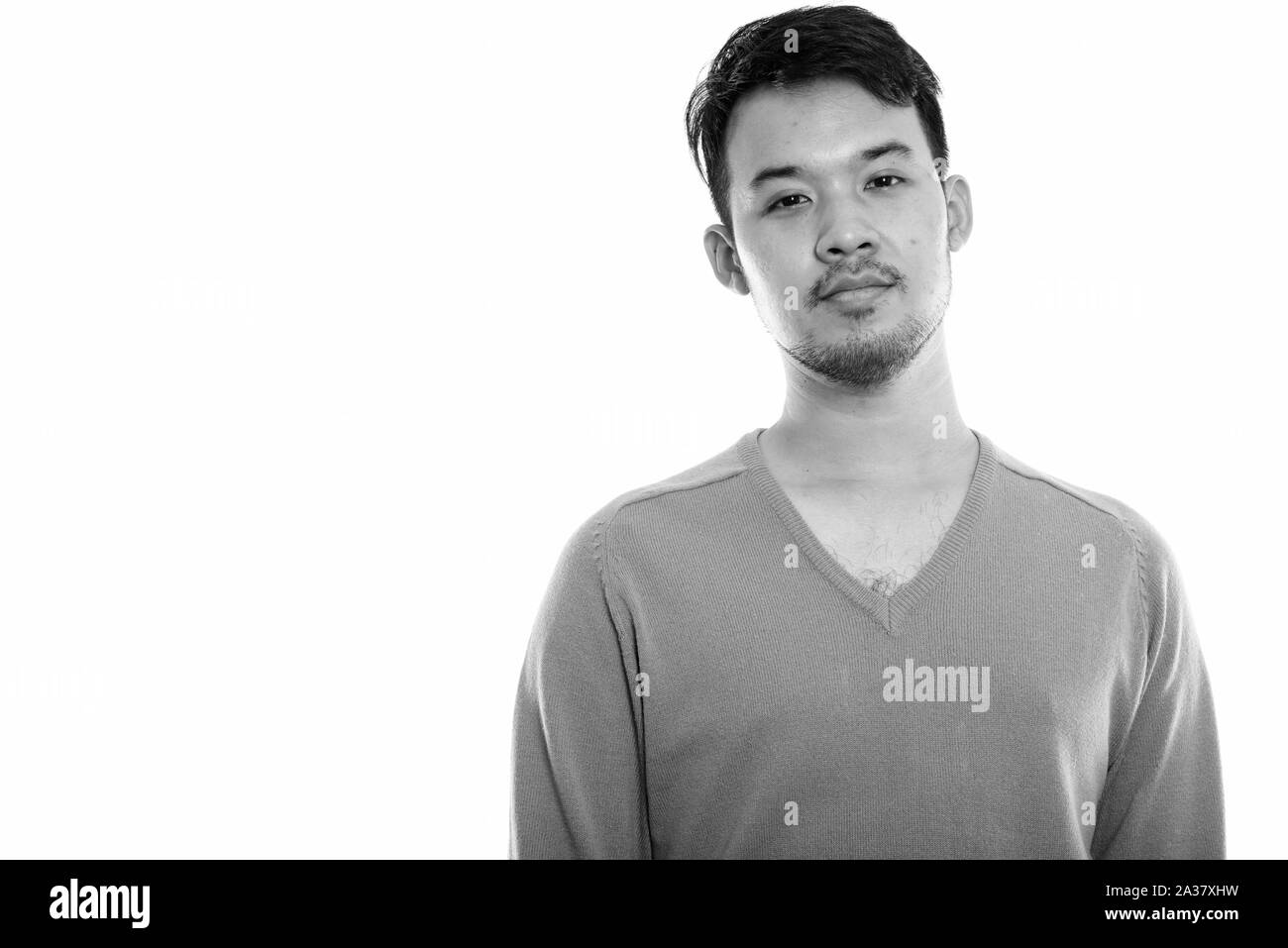 Studio shot of young Asian man en noir et blanc Banque D'Images