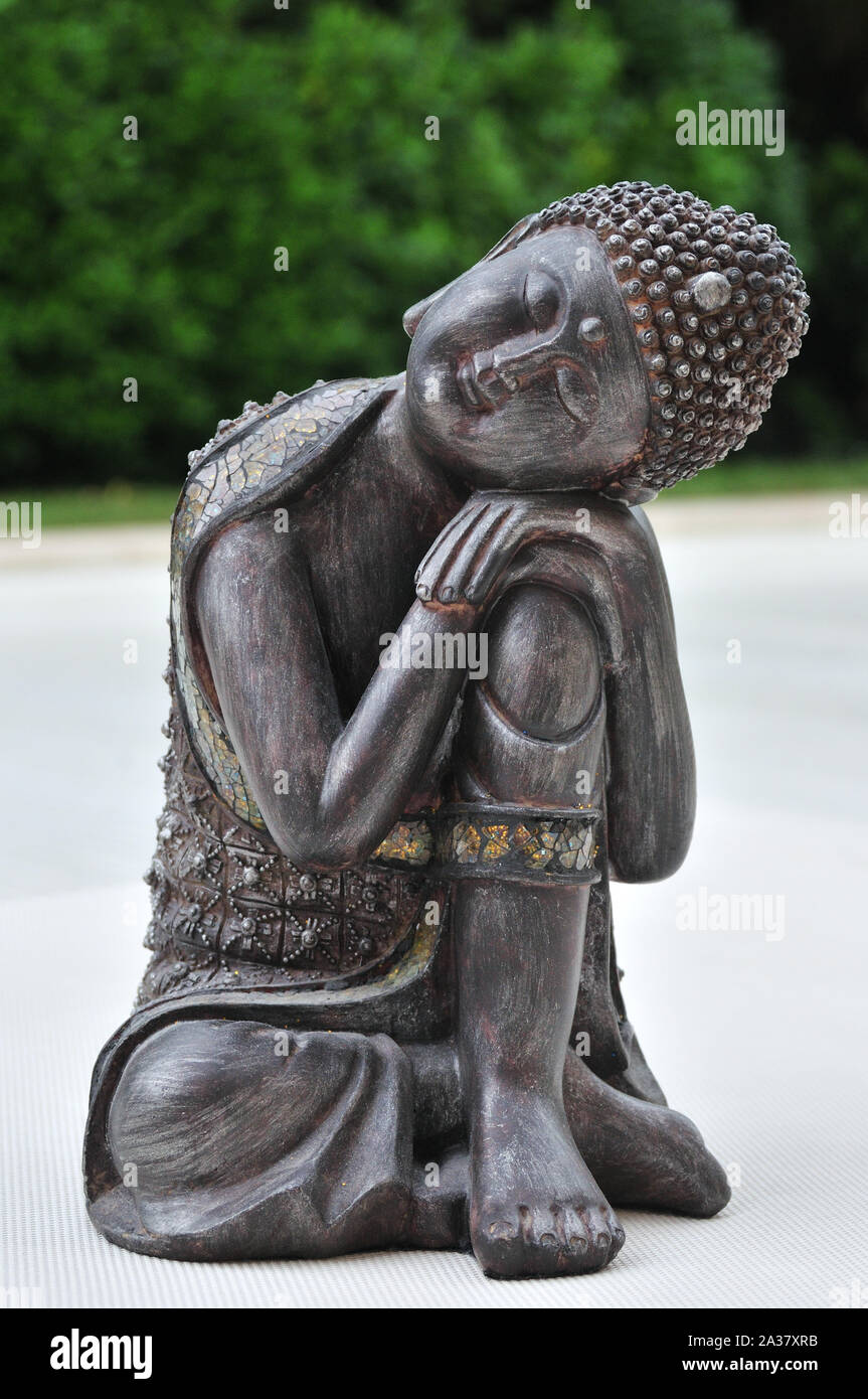 Statuette de Bouddha allongé sur la pierre blanche, inspirant la sérénité, la paix et la tranquillité Banque D'Images