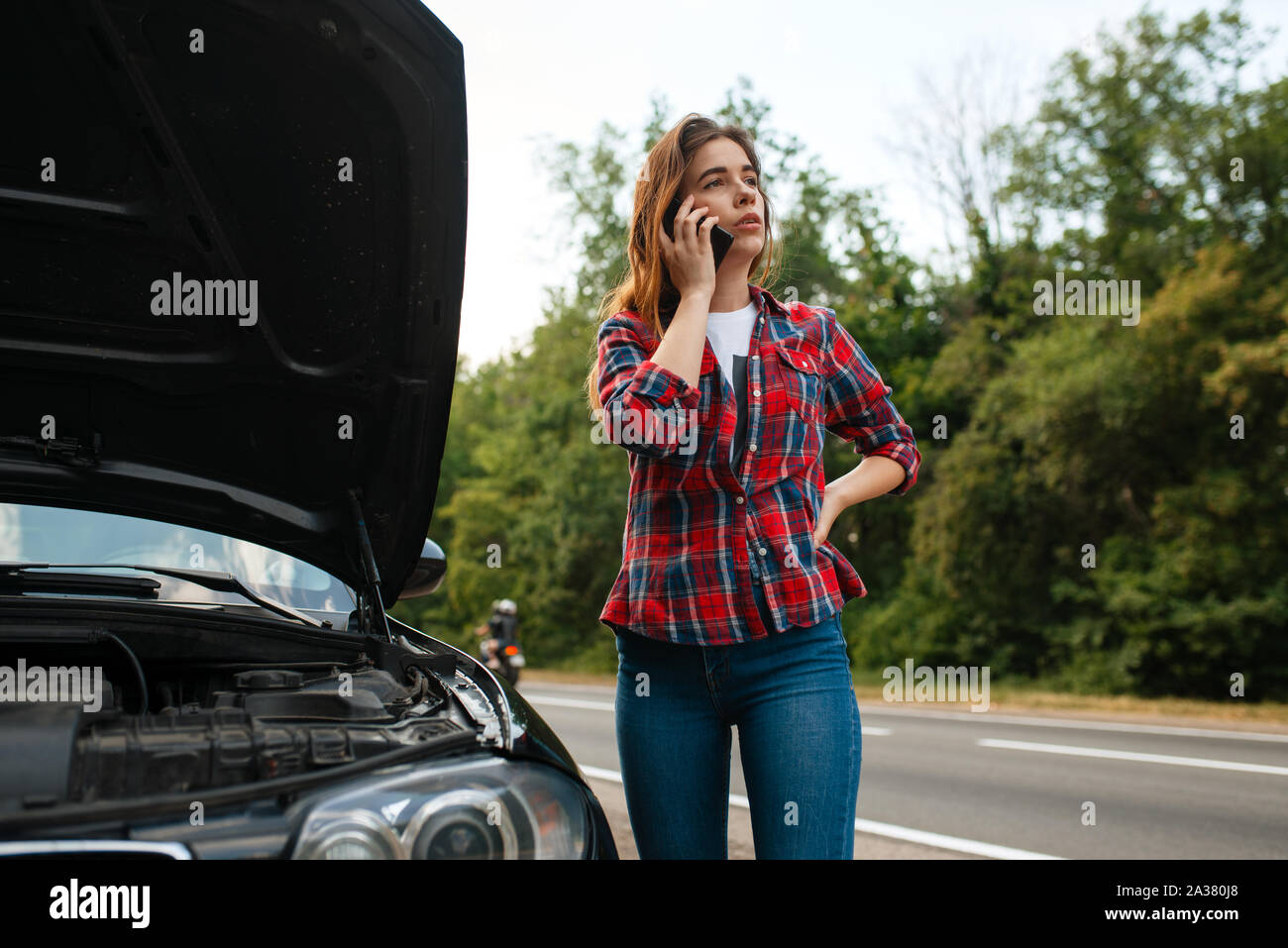 Femme appelant une dépanneuse sur route, panne de voiture Banque D'Images