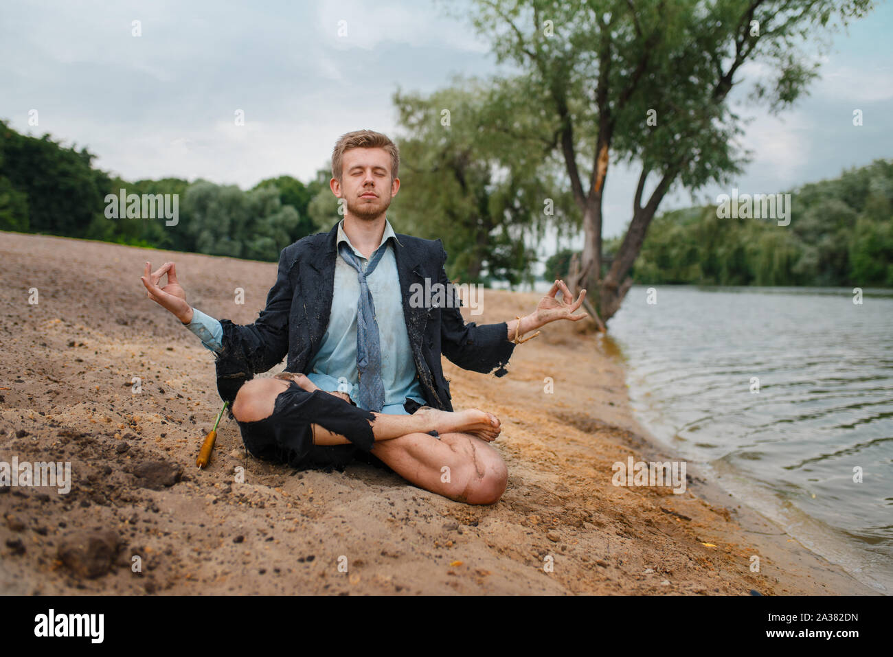 Employée de bureau assis sur la plage en yoga pose Banque D'Images