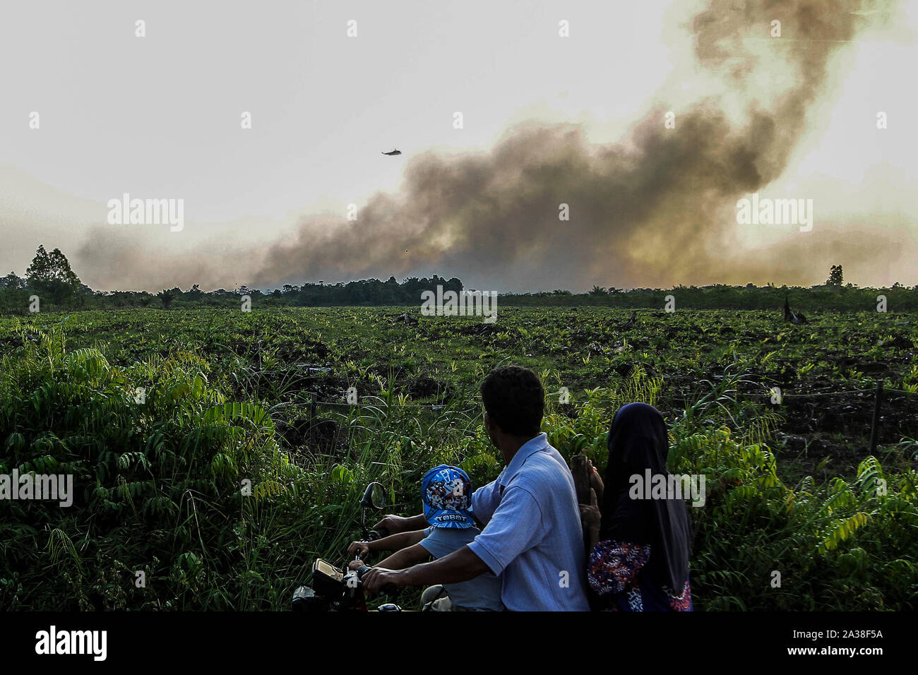 Riau, l'Indonésie. 6 octobre, 2019. Les gens regardent un hélicoptère laissant tomber l'eau sur le feu dans la province de Riau, Kampar, Indonésie, le 6 octobre 2019. Credit : Hadly Vavaldi/Xinhua/Alamy Live News Banque D'Images