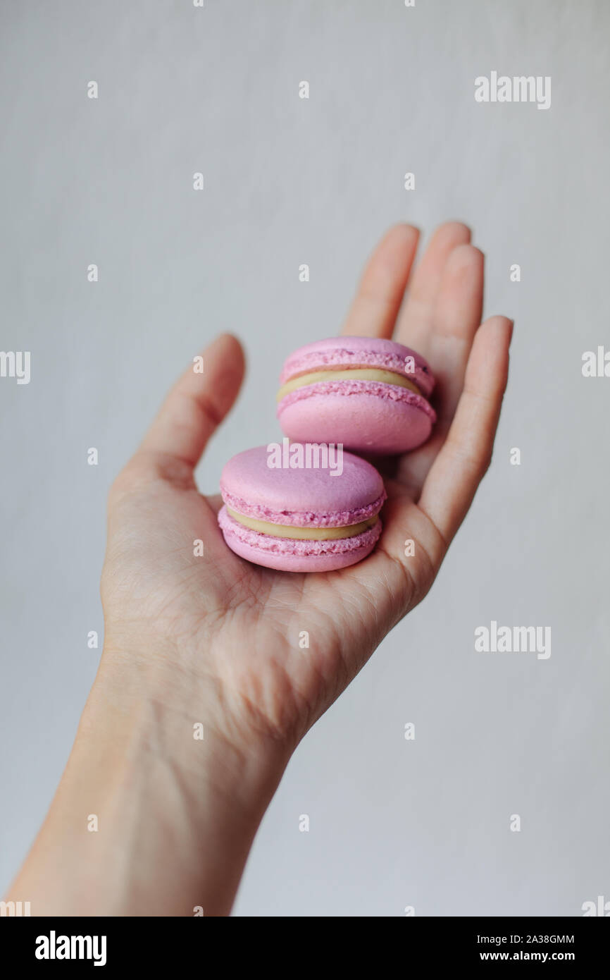 Woman's hand holding deux macarons Banque D'Images