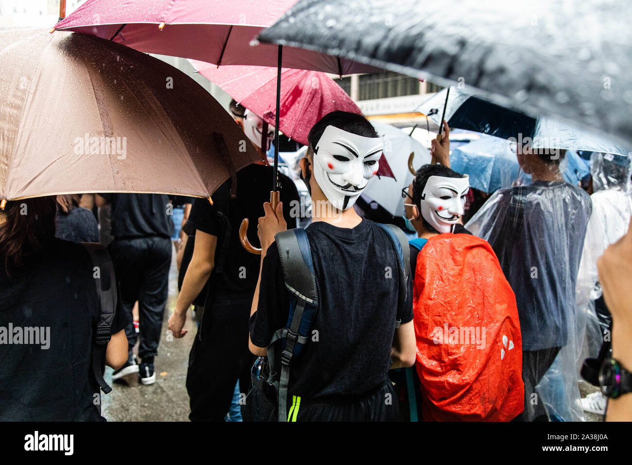 Porter des masques de Guy Fawkes manifestants pendant la manifestation.entrer dans le 18ème week-end d'agitation civile, les manifestants ont marché sous la pluie après un masque anti-loi a été adoptée dans le but d'empêcher les manifestations. Les manifestants scandaient des slogans et continué de solliciter de la cinq exigences à satisfaire. Manifestants ont affronté la police anti-émeute et ont été frappés avec des gaz lacrymogènes, des balles en caoutchouc, et un canon à eau jusqu'à ce que plusieurs ont finalement été arrêtés. Banque D'Images