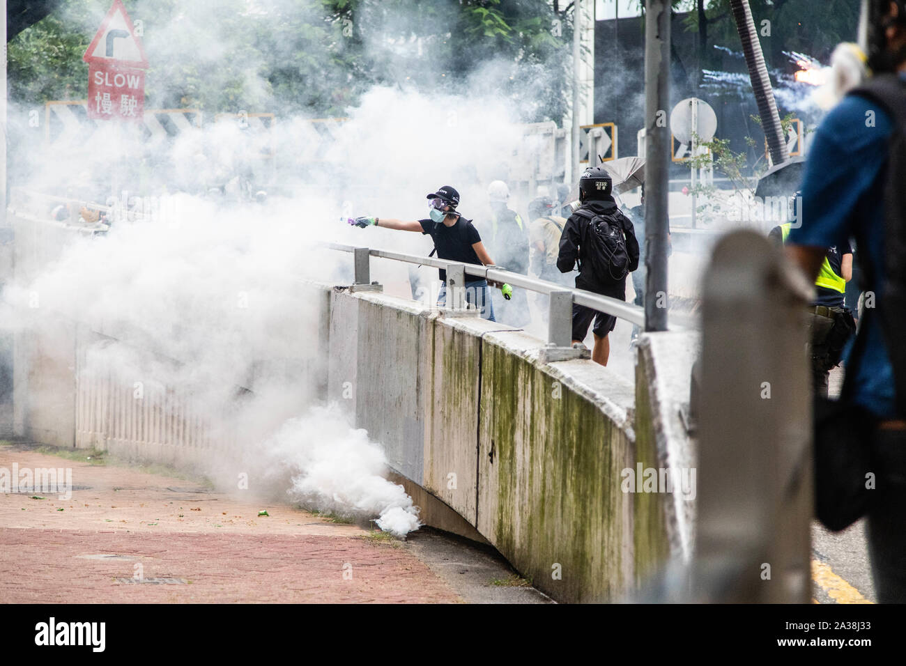 Un manifestant tente d'éteindre avec de l'eau gaz lacrymogènes lors de la manifestation.entrer dans le 18ème week-end d'agitation civile, les manifestants ont marché sous la pluie après un masque anti-loi a été adoptée dans le but d'empêcher les manifestations. Les manifestants scandaient des slogans et continué de solliciter de la cinq exigences à satisfaire. Manifestants ont affronté la police anti-émeute et ont été frappés avec des gaz lacrymogènes, des balles en caoutchouc, et un canon à eau jusqu'à ce que plusieurs ont finalement été arrêtés. Banque D'Images