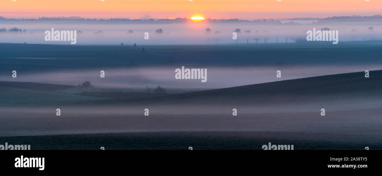 Lever du soleil sur les champs qui rappelle le paysage Toscane Italienne sur un beau matin brumeux Banque D'Images
