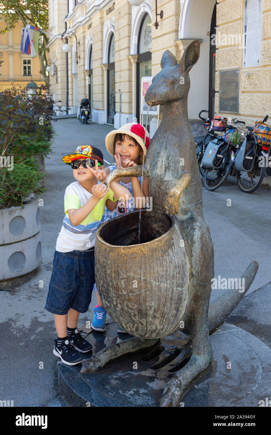 Les enfants à "Kangaroo" fontaine à eau, Krekof trg, Vieille Ville, Ljubljana, Slovénie Banque D'Images