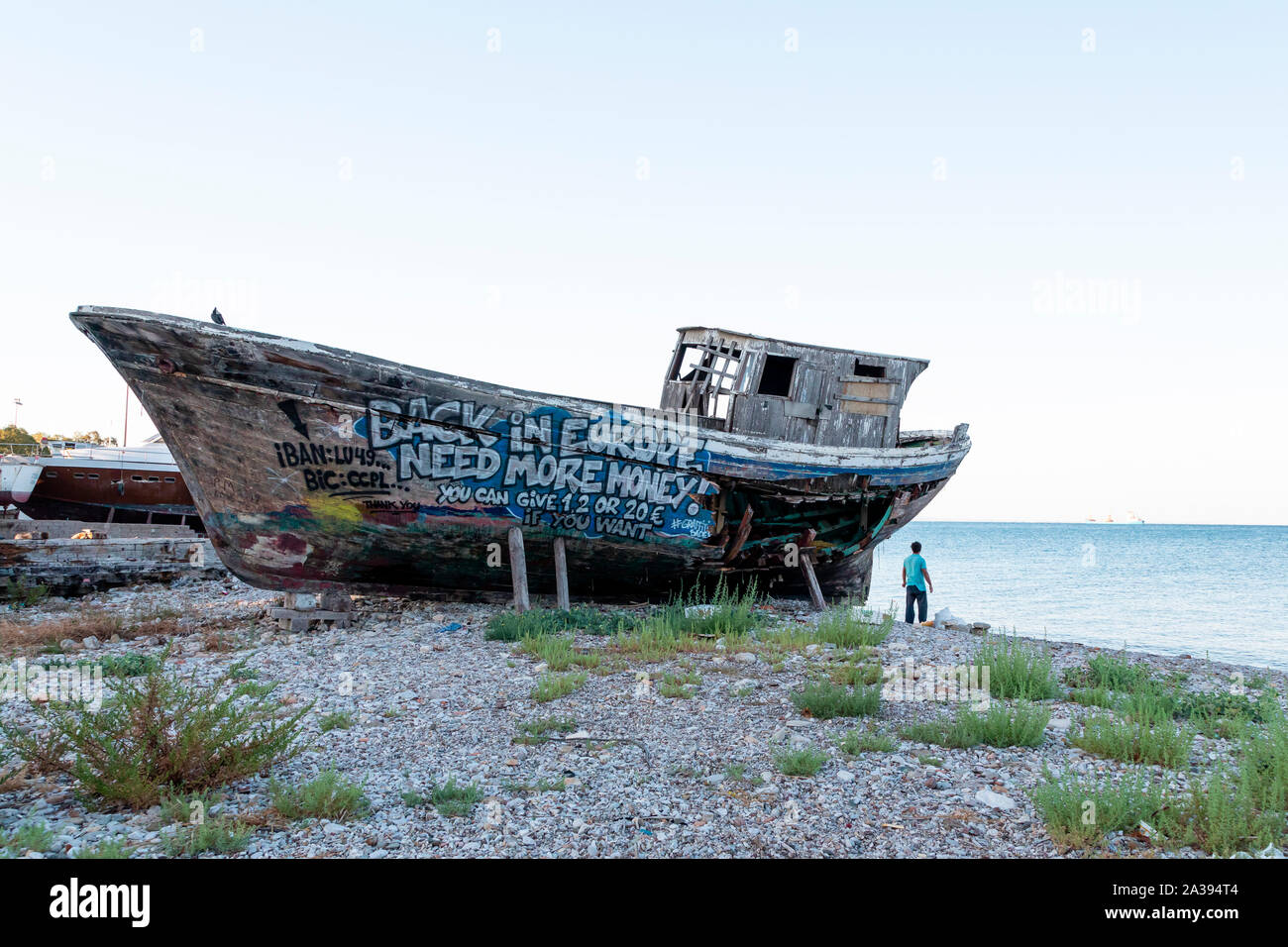 Un vieux bateau de pêche en bois couvert de graffitis sur cale sèche. Banque D'Images