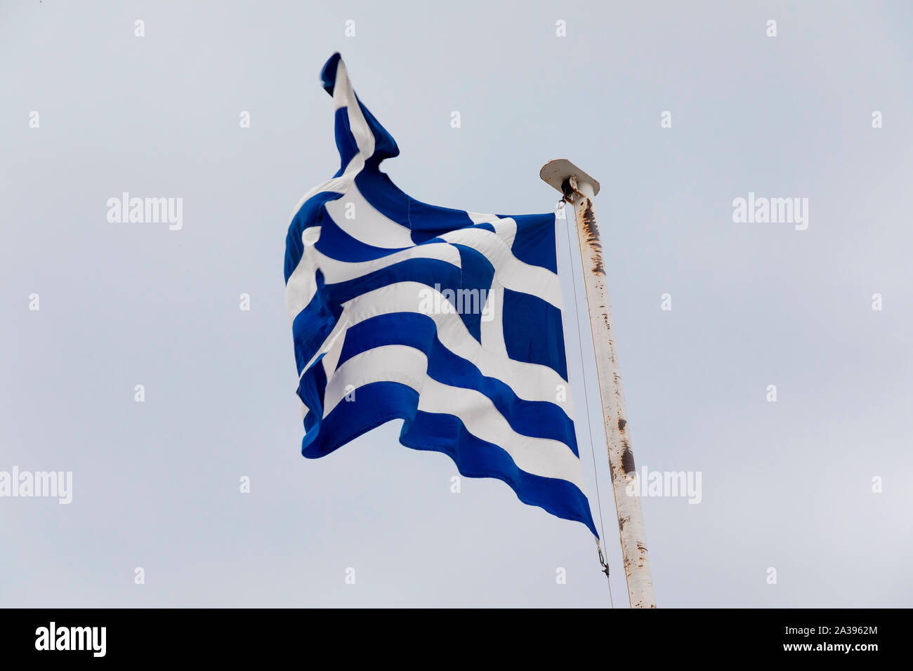Le drapeau grec au vent sur un drapeau blanc poteau. Banque D'Images