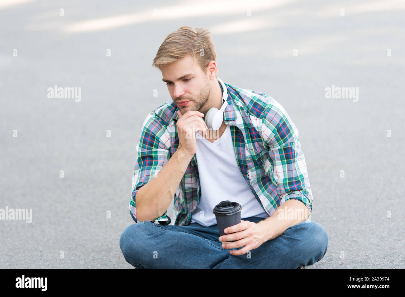 Plus de café. café d'aller. guy boire un café en plein air. L'homme s'asseoir sur le sol. fatigué en étudiant casque. l'éducation en ligne. écouter la musique. ebook concept. homme Chemise à carreaux. élève se détendre et se ressourcer. Banque D'Images