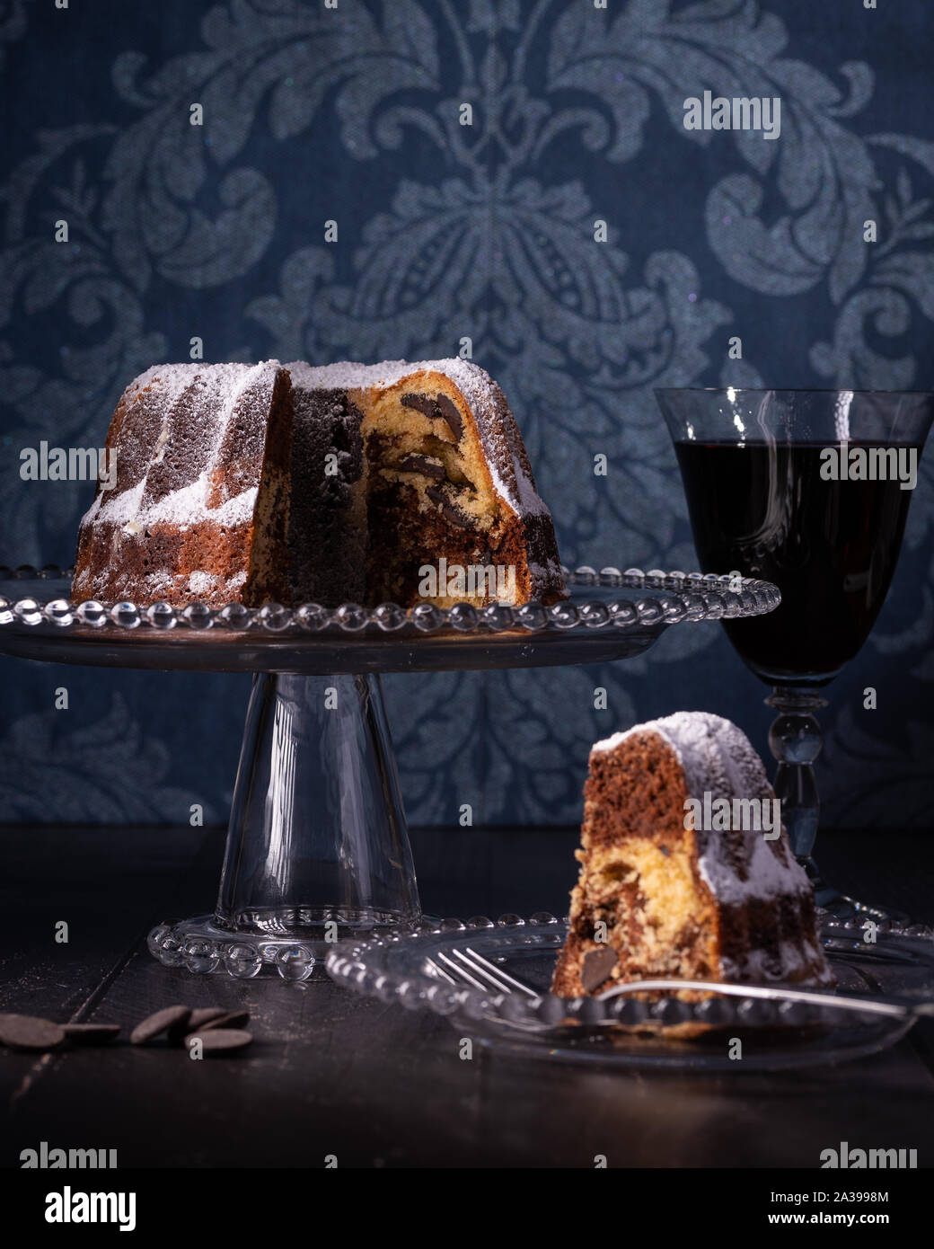 Gâteau marbré Bunt, Vin rouge et bleu foncé fond damassé Banque D'Images