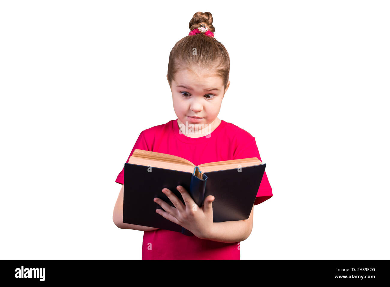 Petite fille lit un vieux livre avec intérêt. Isolé sur un fond blanc. Banque D'Images