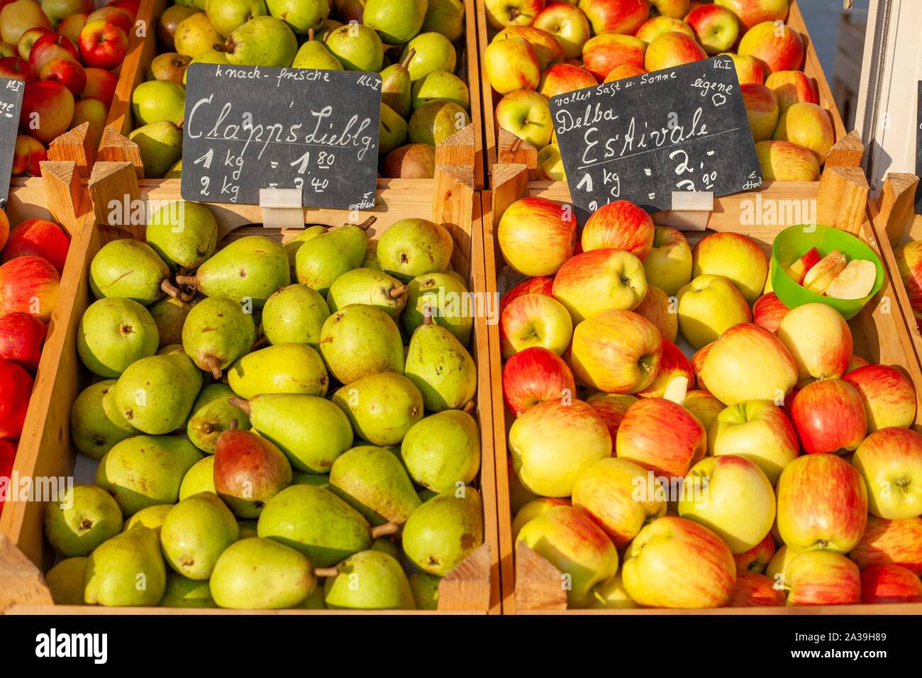 Pommes et poires fraîches avec des étiquettes de prix dans des caisses en bois at a market stall, Allemagne Banque D'Images