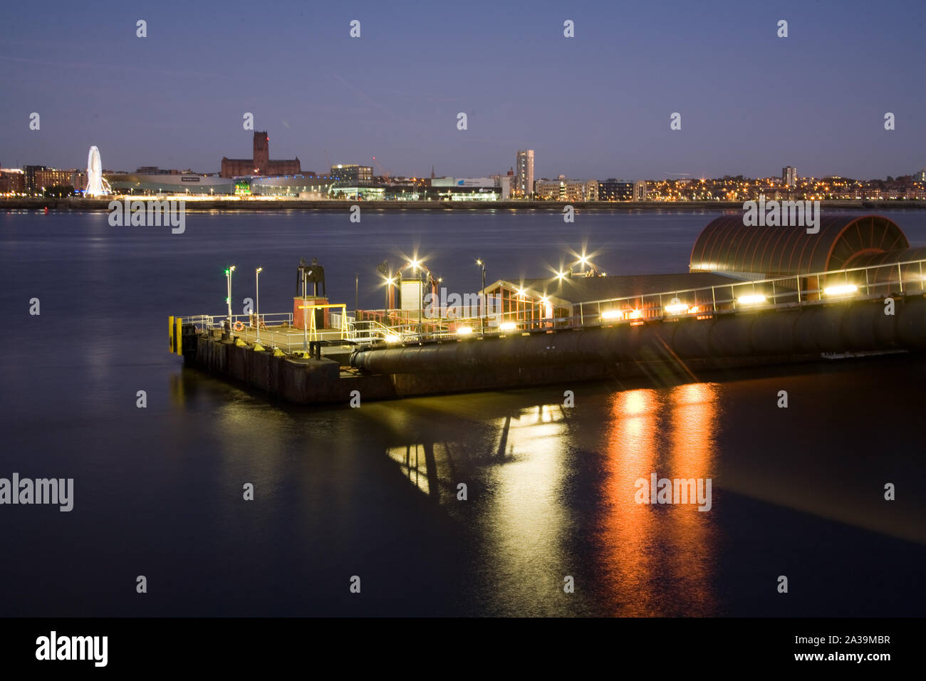 Le terminal de ferry de Woodside à Birkenhead éclairés la nuit, avec l'horizon de la ville de Liverpool sur la Rivière Mersey Banque D'Images