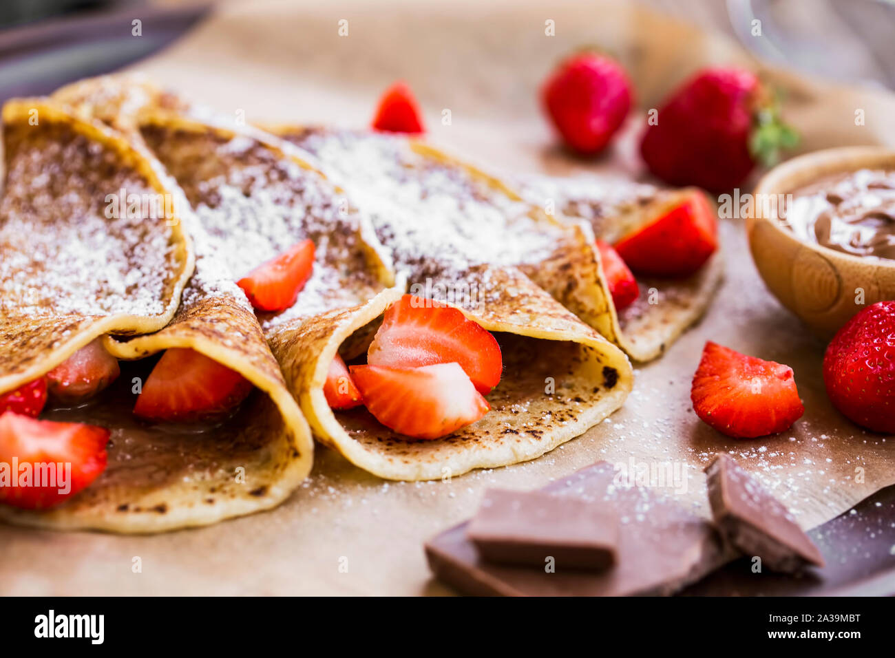 Crêpes français avec pâte à tartiner au chocolat et des fraises, délicieux dessert sucré rempli de crème au chocolat et fraises fruits Banque D'Images
