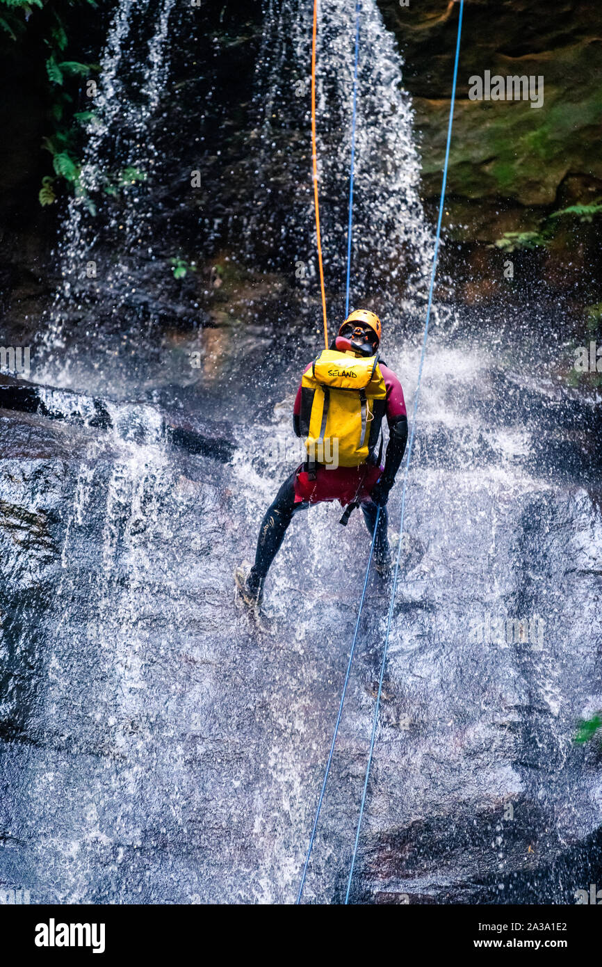 L'impératrice Falls, Blue Mountains, Australie - 7 Sept 2019 : l'homme est abaissé long drop cascade sur roches glissantes, le port de sac à dos, avec Banque D'Images