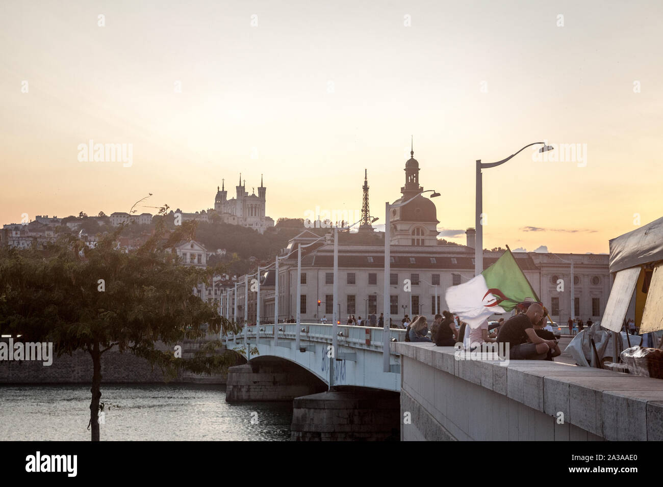 LYON, FRANCE - 14 juillet 2019 : l'homme renonce à un drapeau algérien dans le centre de Lyon, avec des monuments tels que la Basilique Notre Dame de Fourvière, de l'Église Banque D'Images