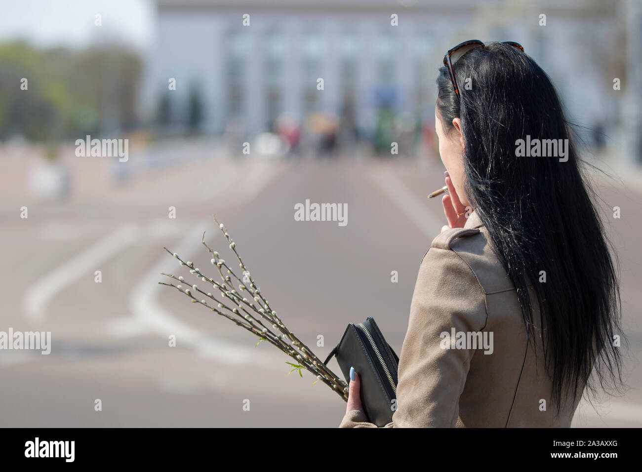 Biélorussie, Minsk, le 21 avril 2019. Dimanche des Rameaux est une église maison de vacances.femme avec une cigarette et une branche de saule dans le contexte de la ville. Banque D'Images