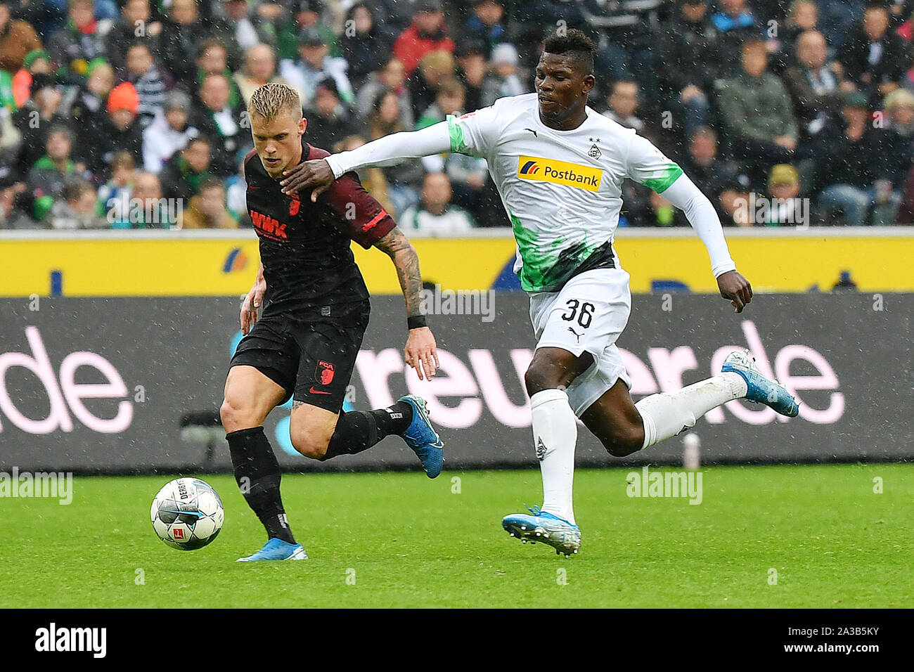 (191007) -- MONCHENGLADBACH, le 7 octobre 2019 (Xinhua) -- La Grosse Caye Breel (R) de Monchengladbach rivalise avec Philipp Max d'Augsbourg au cours de la Bundesliga match de foot entre Borussia Mönchengladbach et FC Augsburg à Mönchengladbach, Allemagne, le 6 octobre 2019. (Photo par Ulrich Hufnagel/Xinhua) Banque D'Images