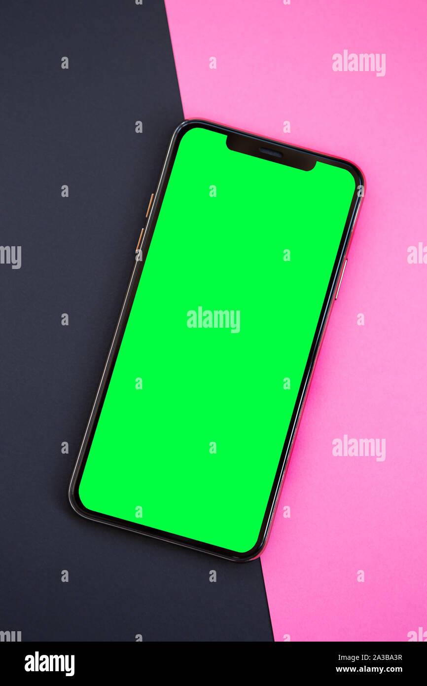 Nouveau smartphone avec grand écran vert.téléphone mobile avec écran tactile dans vide télévision jeter sur fond noir et rose.Placer le logo de l'application sur l'em Banque D'Images