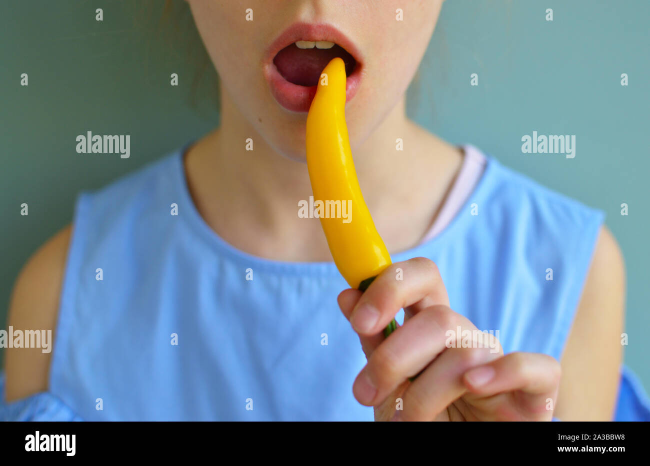 Petit shot of girl eating piment jaune Banque D'Images