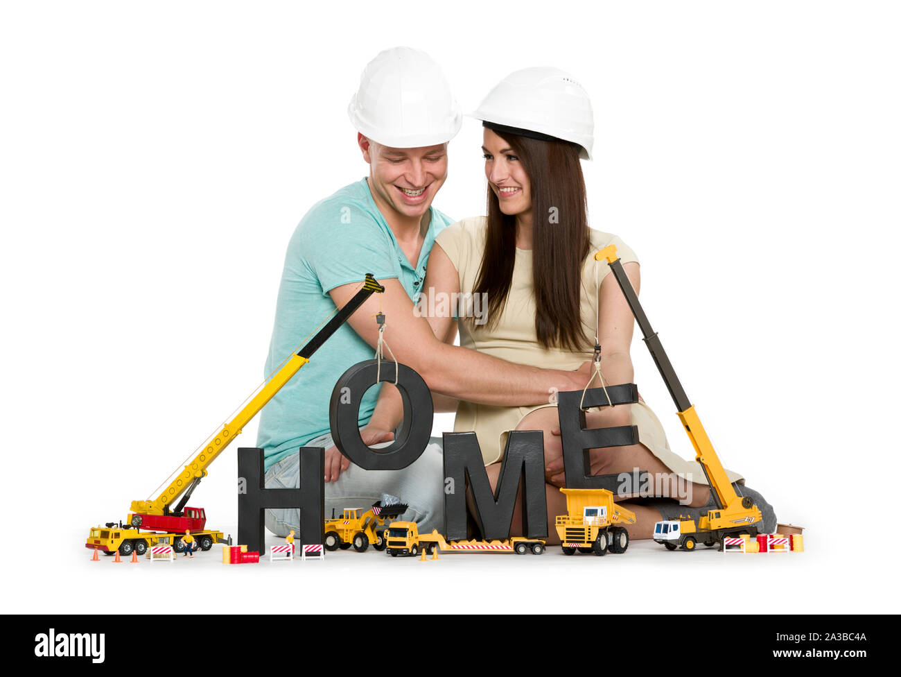 Accueil en construction : heureux couple avec des machines immeuble accueil-word. Banque D'Images