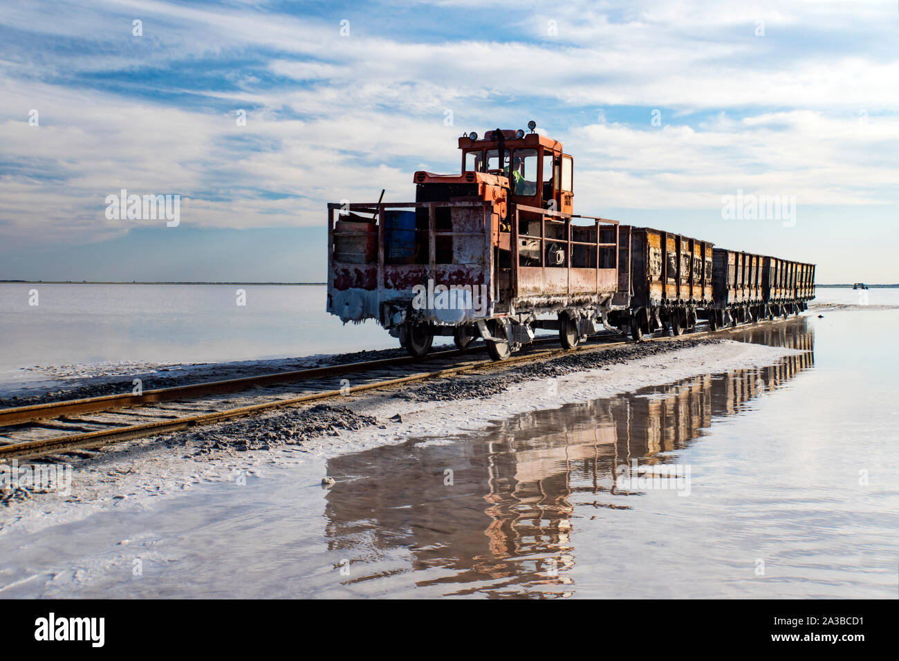 Super train rides sur le rail dans l'eau avec sel blanc sur le fond de ciel bleu. Banque D'Images