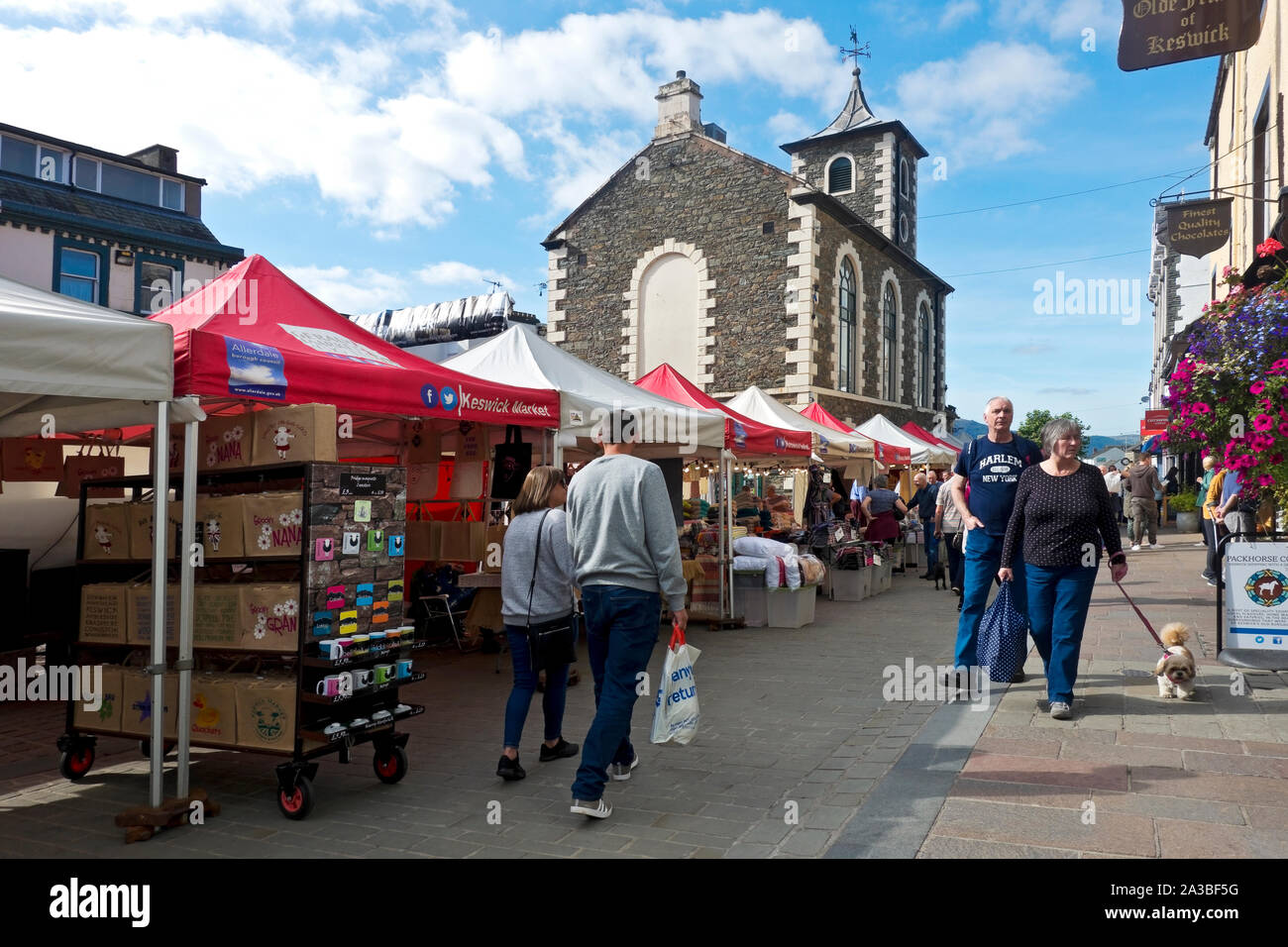 Gens touristes visiteurs à l'extérieur jeudi marché stalle stalles dans l'été Market Square Keswick Cumbria Angleterre Royaume-Uni Grande-Bretagne Banque D'Images