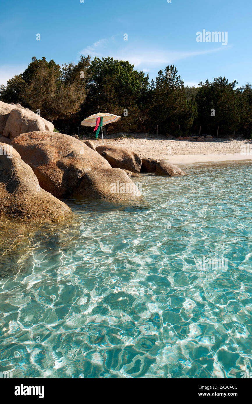 Eau claire isolée, plage de sable blanc et rochers avec parasol / Plage de Santa Giulia / plage de Santa Giulia, plage d'été Porto-Vecchio Corse Banque D'Images