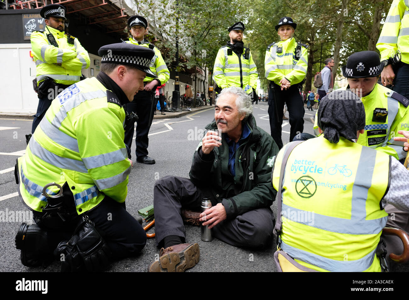 Westminster, London, UK - Lundi 7 octobre 2019 - Rébellion Extinction XR les manifestants bloquer les routes autour de Westminster - agents de police avertir un manifestant de l'arrestation imminente à Millbank près de Parlement. Photo Steven Mai / Alamy Live News Banque D'Images