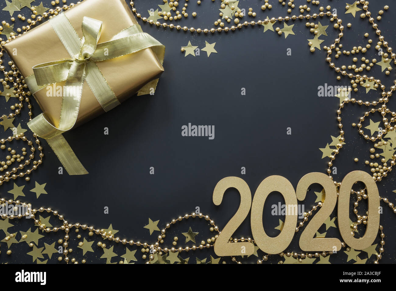 Luxury golden boîte-cadeau avec date de 2020 sur fond noir. Le lendemain de Noël. Mise à plat. Vue de dessus. Noël. Nouvelle Année. Banque D'Images