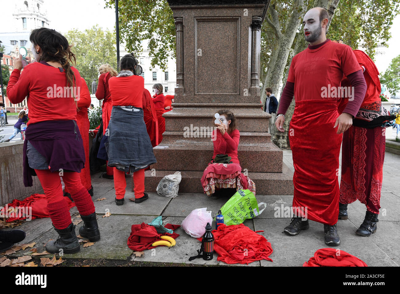 Des membres de "La Brigade Rouge' entrer dans le costume et appliquer du maquillage pour une rébellion d'extinction en protestation Westminster, Londres. Banque D'Images