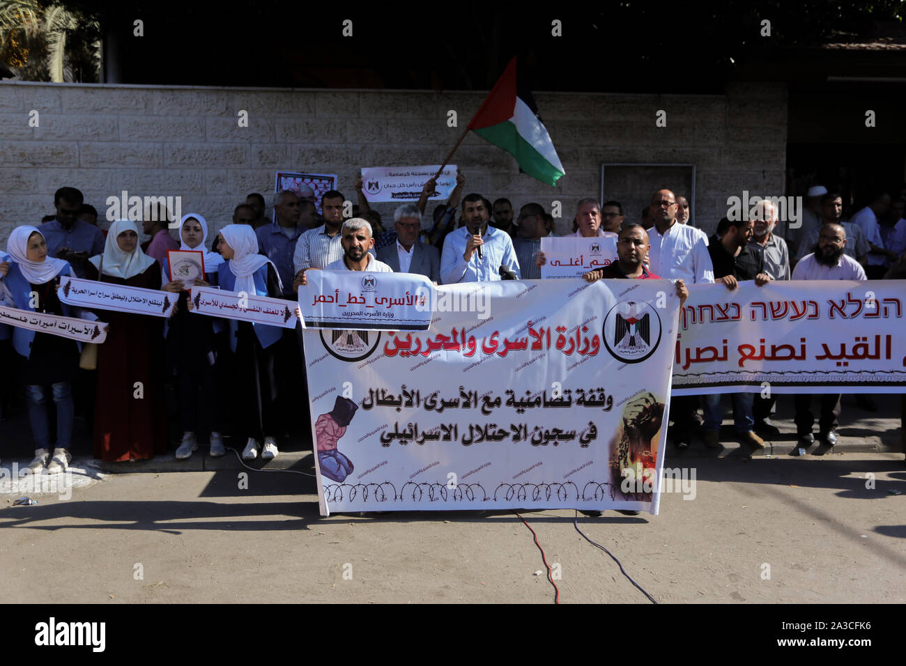 Les manifestants tiennent des banderoles, des pancartes et un drapeau pendant la manifestation.Palestiniens organiser une manifestation en solidarité avec les prisonniers dans les prisons israéliennes, en face de la Croix Rouge bureau de Gaza, en Palestine. Banque D'Images