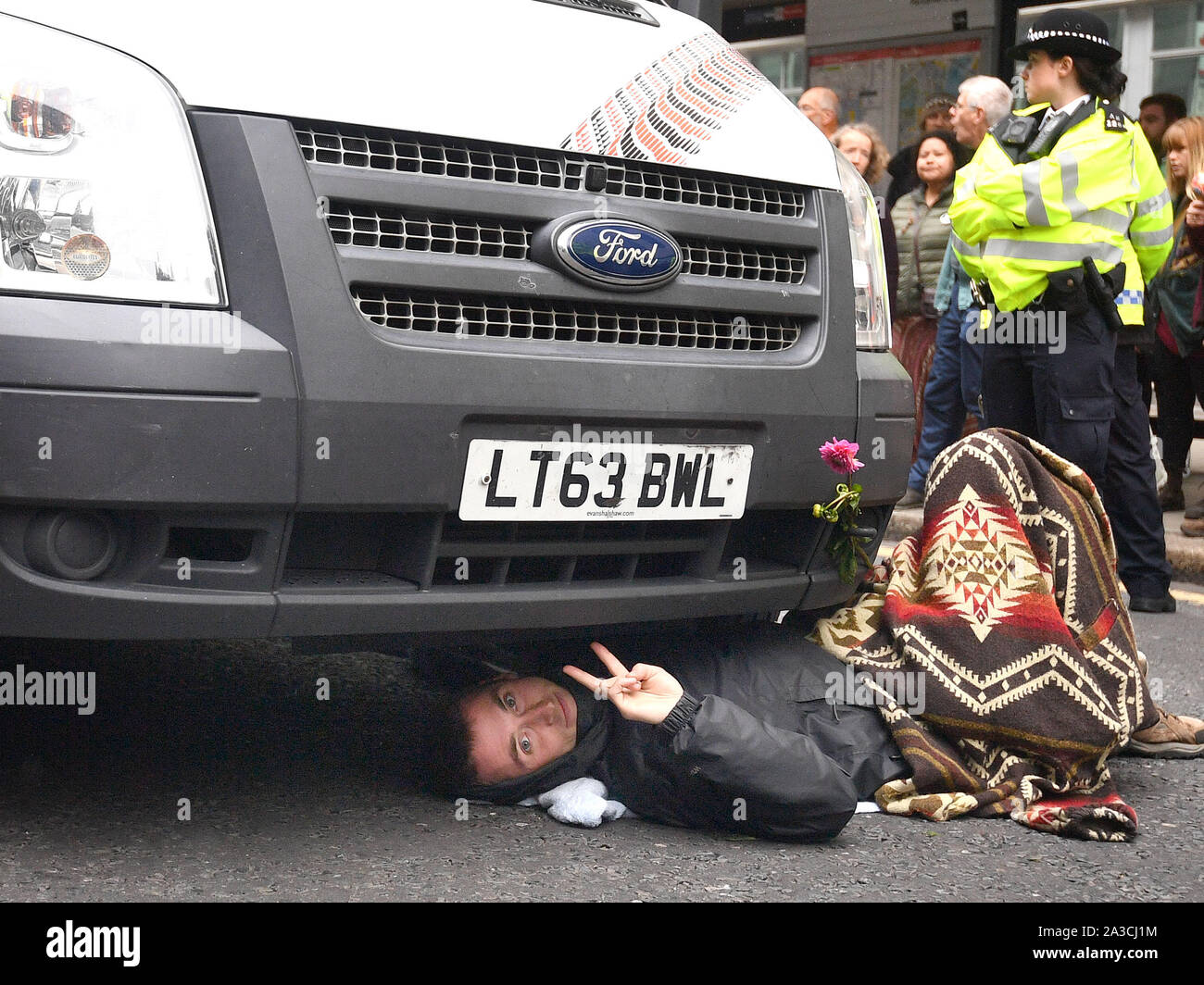 L'extérieur du gouvernement Ministère des entreprises, de l'énergie et de stratégie industrielle, un manifestant qui s'est enchaînée à un véhicule bloque la rue Victoria au cours d'une rébellion d'Extinction manifestation à Westminster, Londres. Banque D'Images