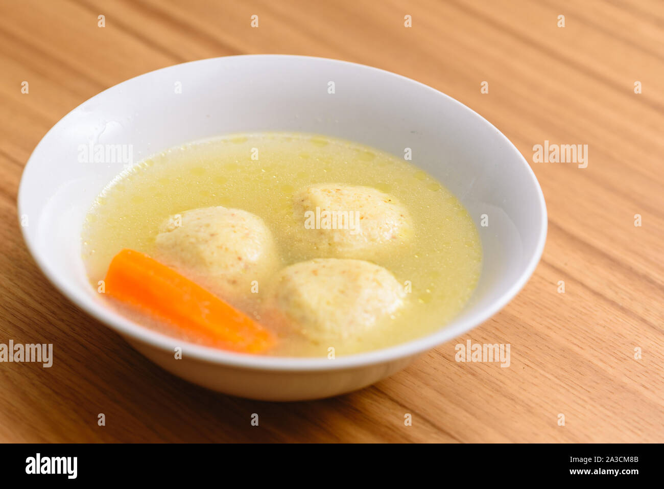 La matsa traditionnelle soupe kneidlach ball.bol blanc avec d'authentiques matzo ball goût poulet soupe bouillon tradition alimentaire pour la Pâque juive et de tous les jours. Banque D'Images