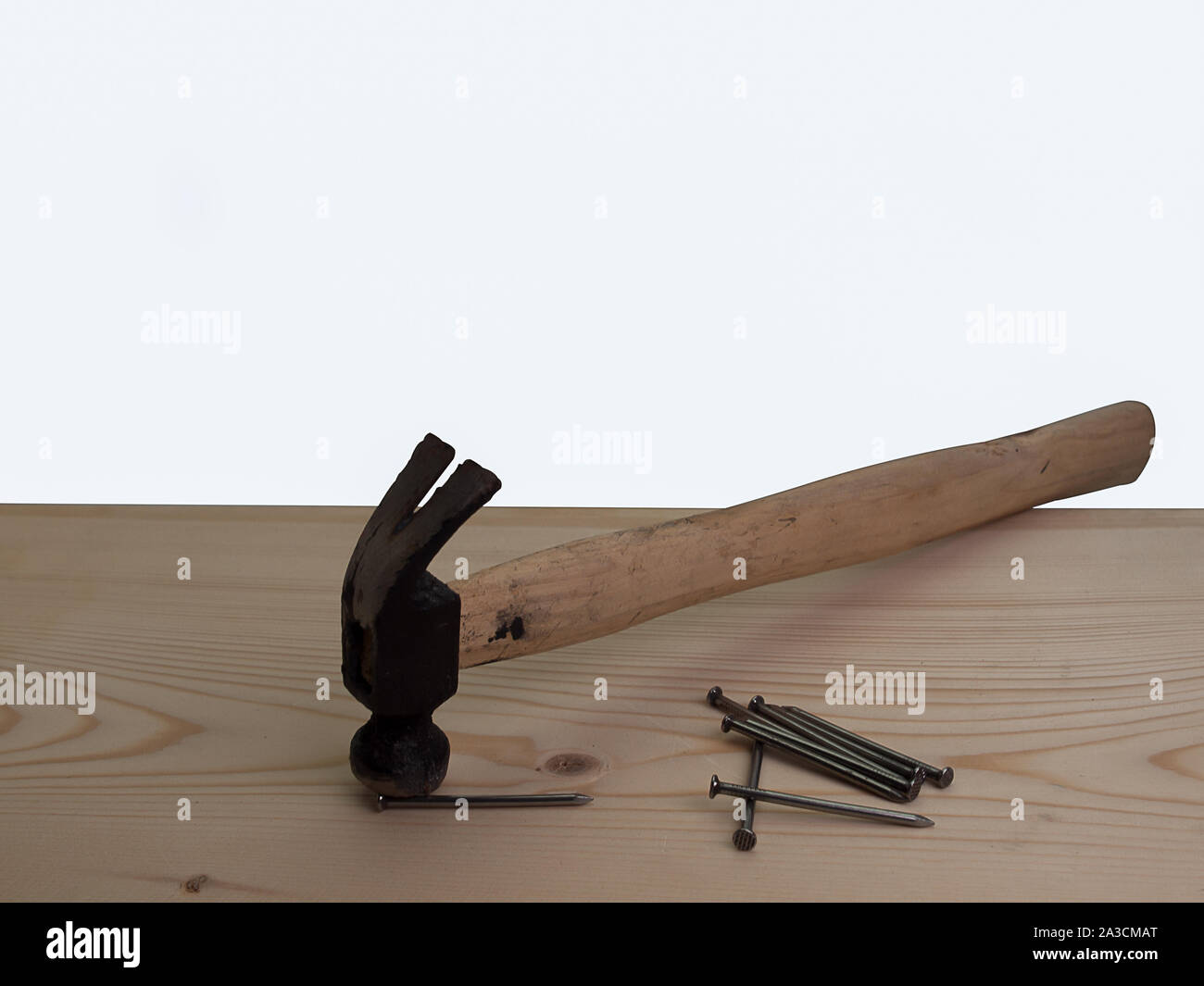 Marteau et d'un ongle , placé sur une table en bois. Banque D'Images