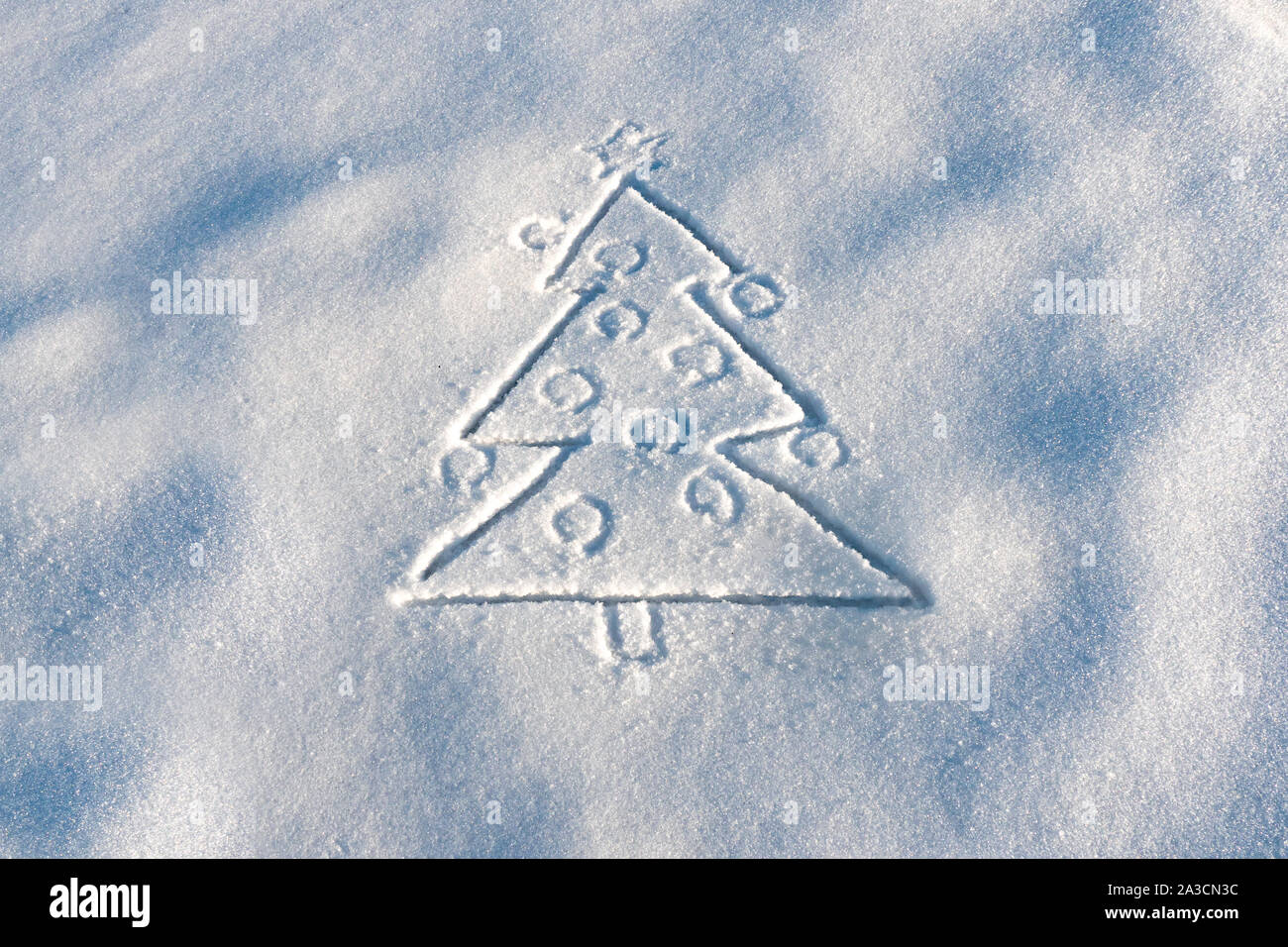 Tirée de l'arbre de Noël sur la neige. S'appuyant sur la surface de la neige. L'hiver, l'hiver bonjour. Sapin avec des boules de Noël dessiné sur la neige blanche. Arbre de Noël dessiné sur la neige. La veille du Nouvel An. Copier l'espace. Banque D'Images