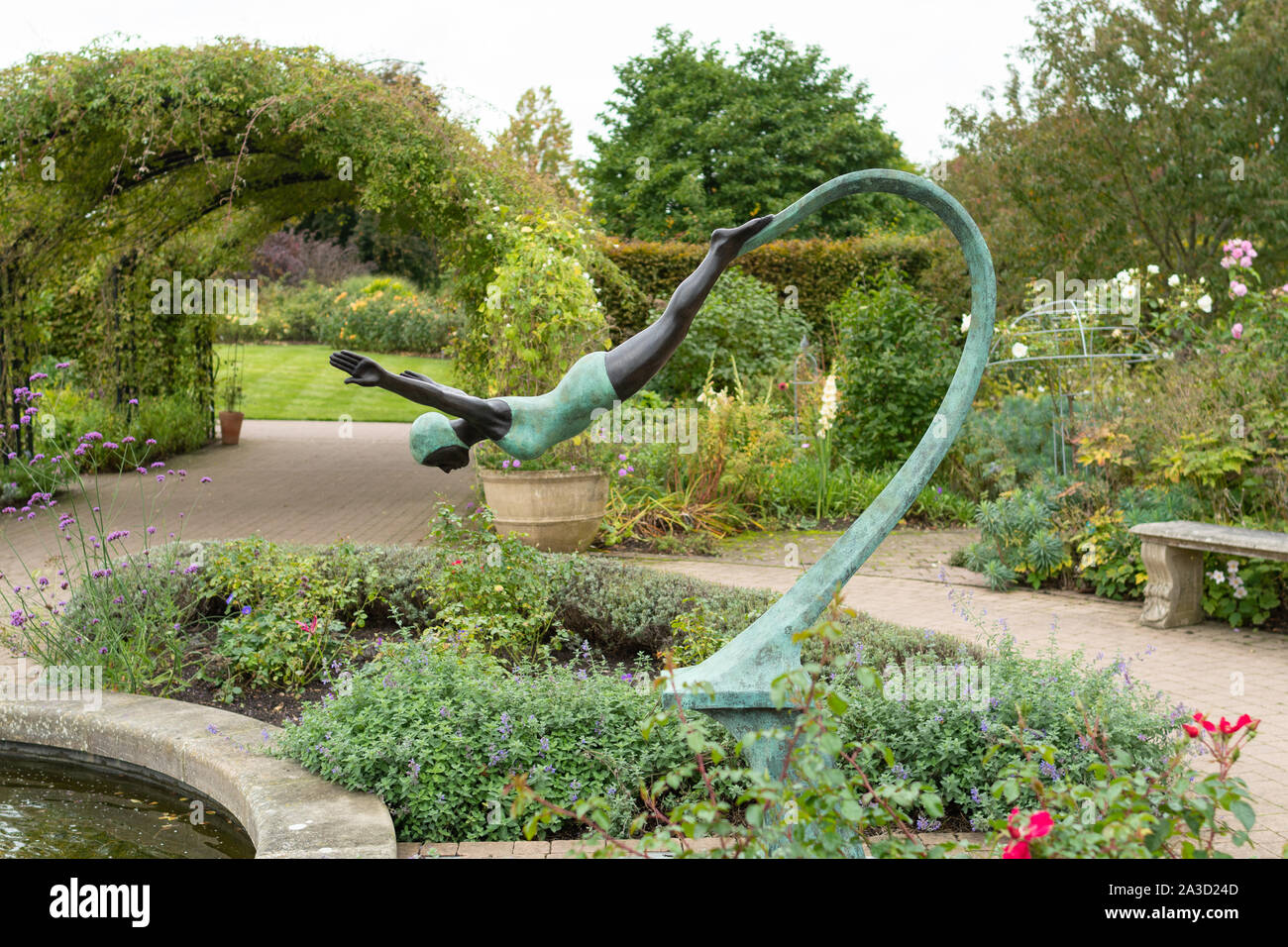 Dame de plongée à côté d'une sculpture de l étang à Wisley RHS Garden Banque D'Images