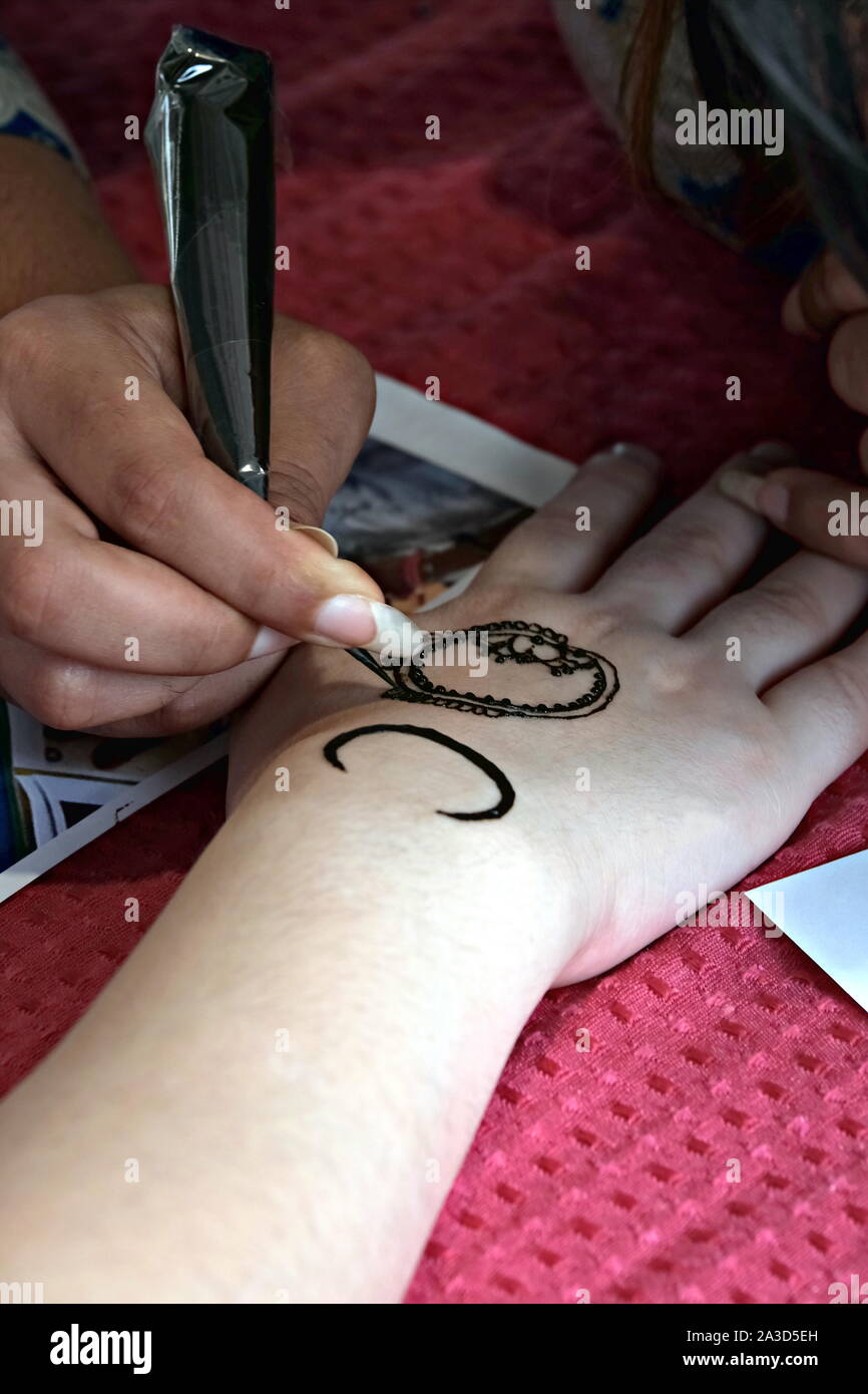 L'application de l'artiste tatouage au henné sur les mains des femmes. Décoration traditionnelle indienne est Mehndi art. Close-up Banque D'Images