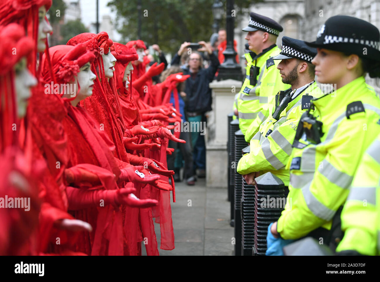 Les manifestants, surnommés les rebelles Rouge, à l'extérieur de l'armoire Bureau sur Whitehall, au cours d'une rébellion d'Extinction (XR) Manifestation à Westminster, Londres. Banque D'Images