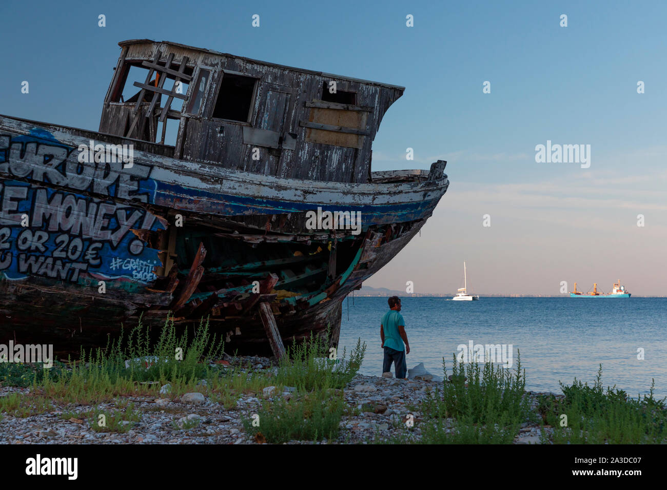 Un vieux bateau de pêche en bois couvert de graffitis sur cale sèche. Banque D'Images