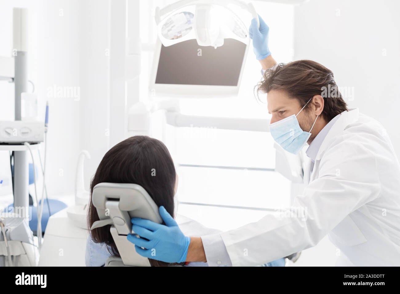 Dentiste attrayant réconfortant female patient sitting in chair Banque D'Images