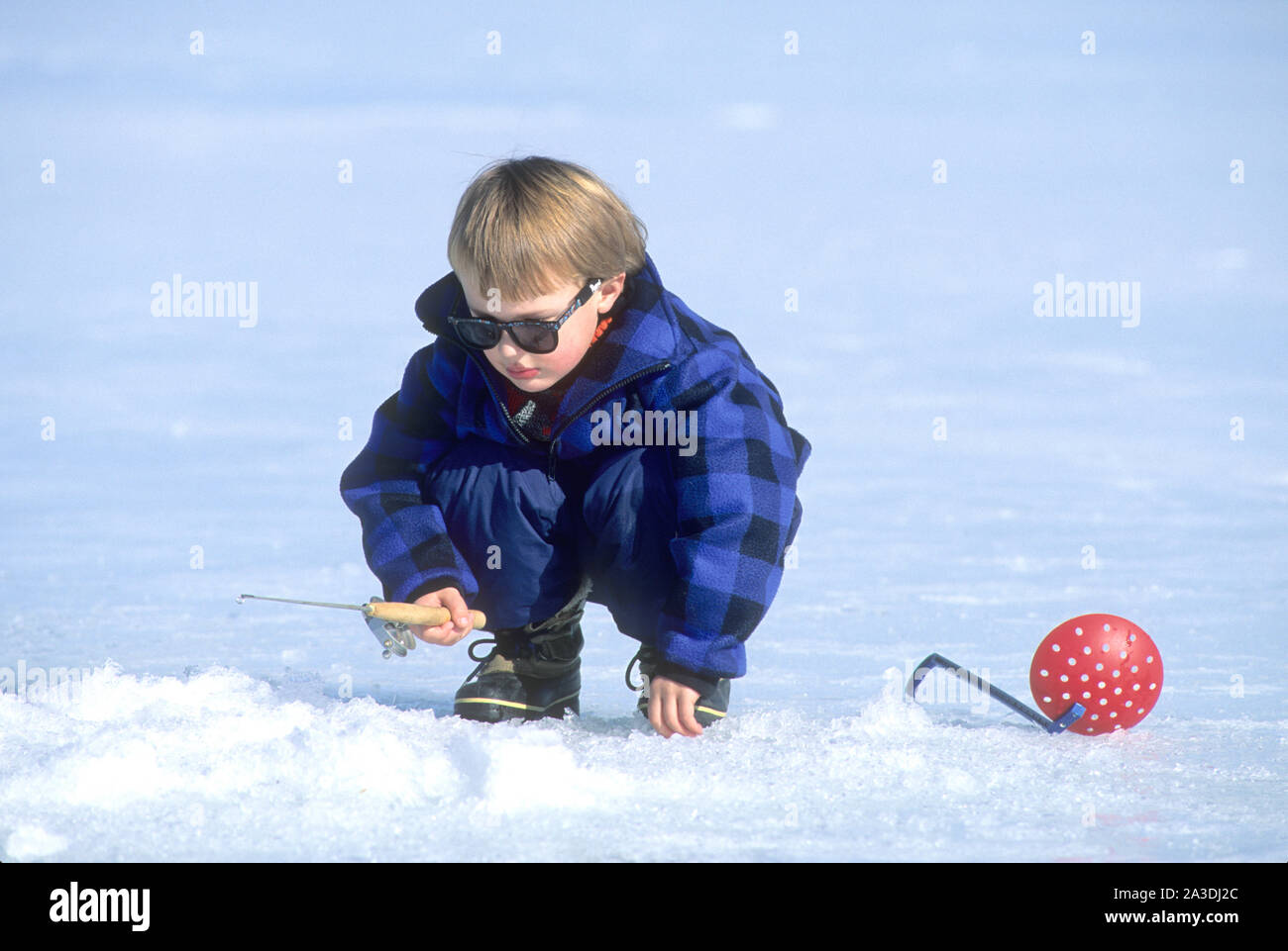 Jeune garçon (âge 3 ans) pêche sur glace la perche à Cascade, Colorado Réservoir Banque D'Images