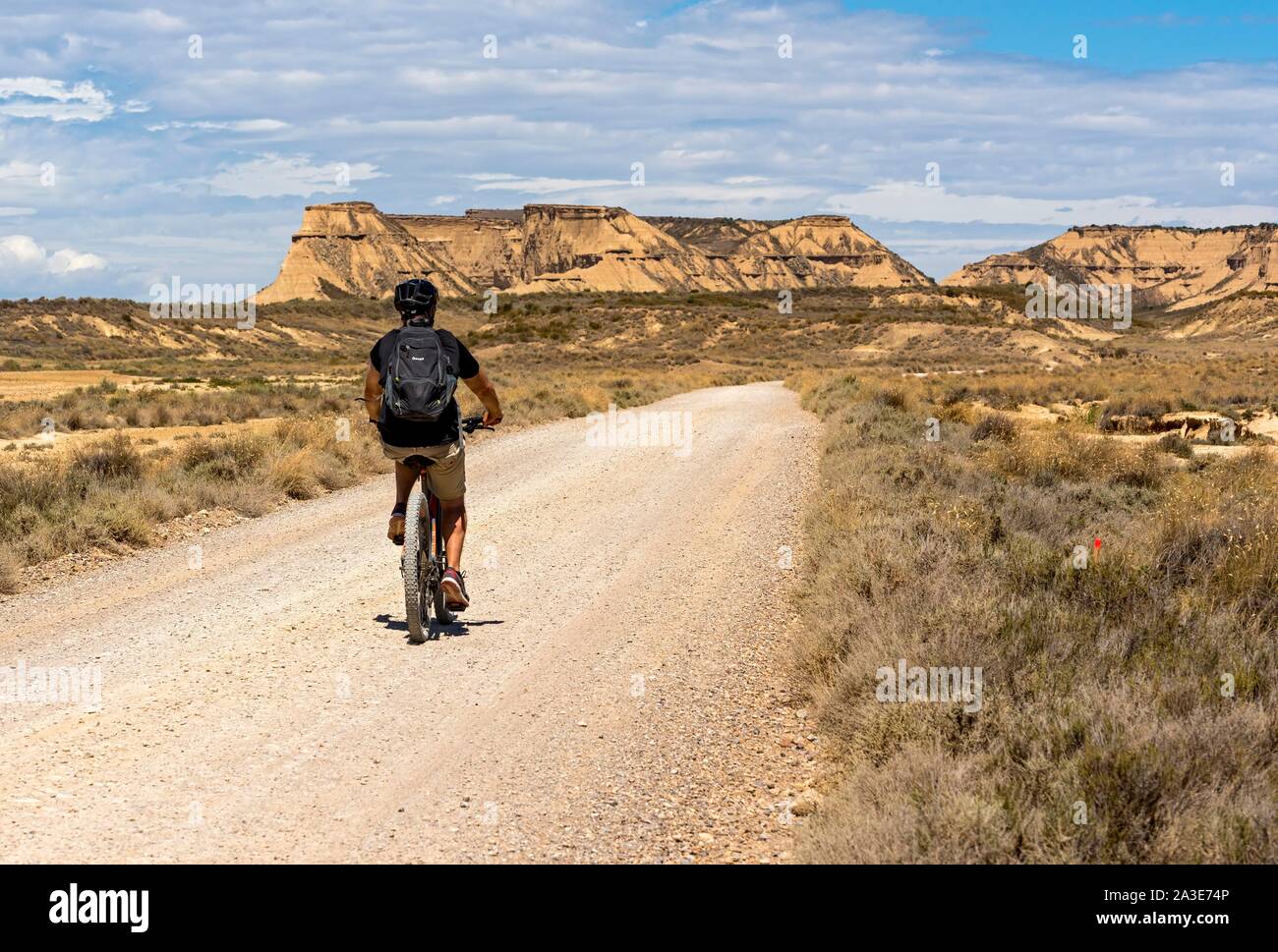 Cycliste sur une route dans le désert de Bardenas Reales, Navarre, Espagne Banque D'Images