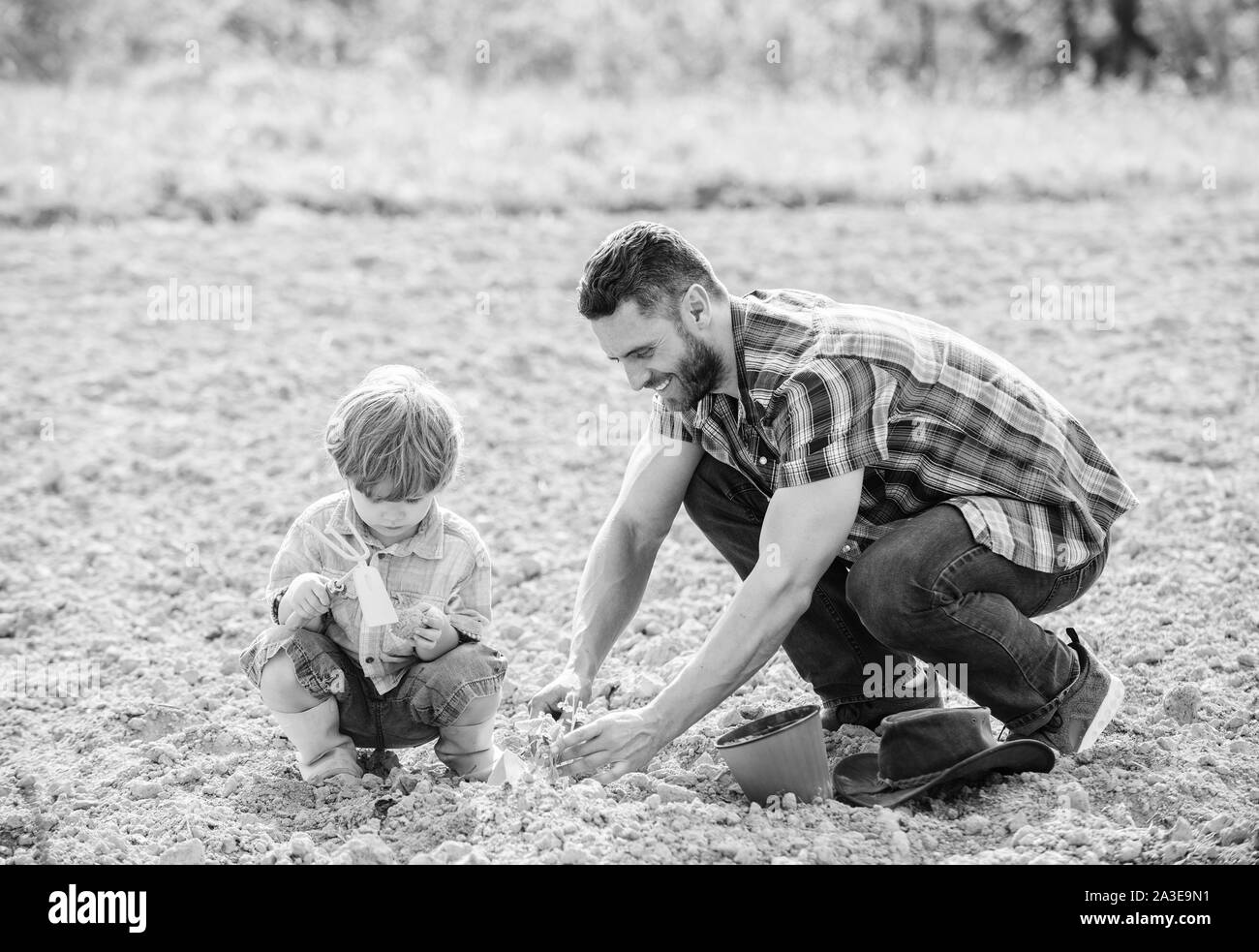 Le jour de la terre. petit garçon enfant père aide à l'agriculture. heureux le jour de la terre. Arbre généalogique. riche sol naturel. Eco farm. S'amuser. Sols et engrais. père et fils, planter des fleurs dans la masse. Banque D'Images
