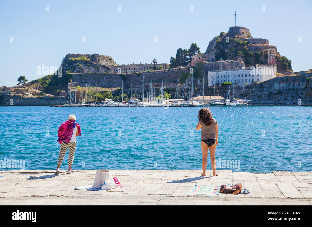 Les femmes du côté du port avec l'ancienne forteresse vénitienne sur l'île grecque de Corfou, Grèce Banque D'Images