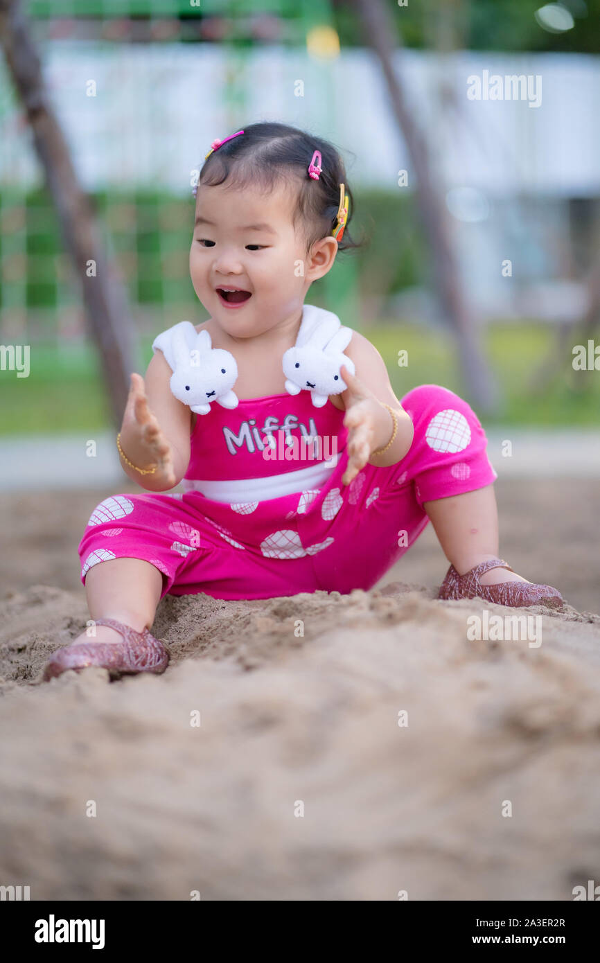 Happy kid girl playing in sand le parc naturel. Banque D'Images