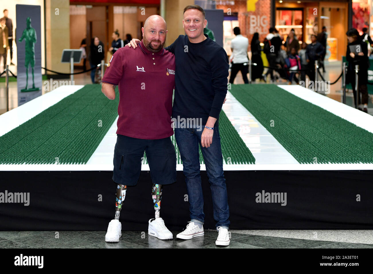 L'acteur Antony Cotton (droite) et le vétéran Dave Watson (à gauche) en face de la force du modèle de 40 000 militaires qui représentent chaque personne médicalement renvoyés de l'Armée en 20 ans et n'est dévoilé à l'Arndale Centre de Manchester. Banque D'Images