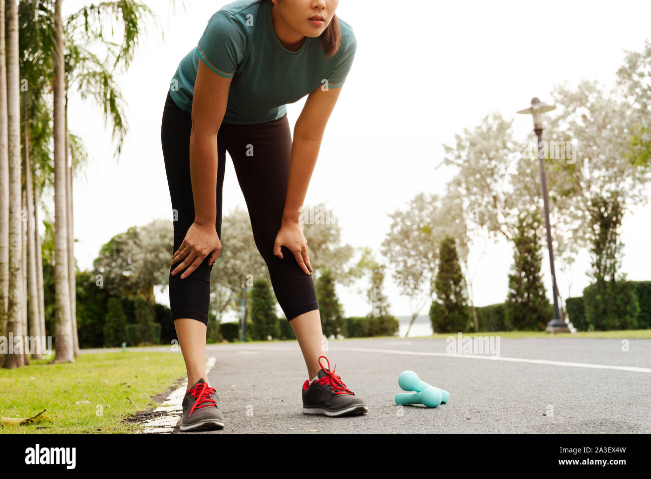 Remise en forme fatigué femme prendre du repos après l'entraînement dur sur le parc Banque D'Images